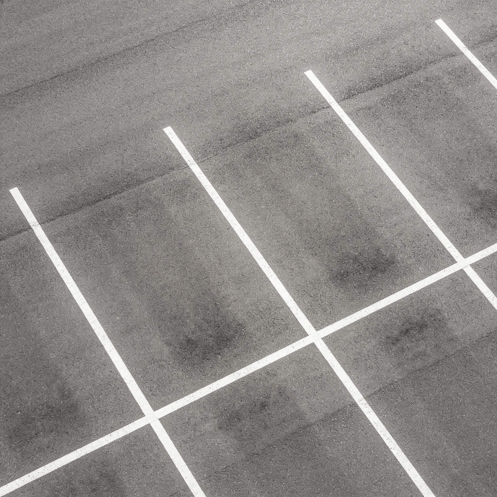 Lege parkeerplaats met witte belijning van bovenaf